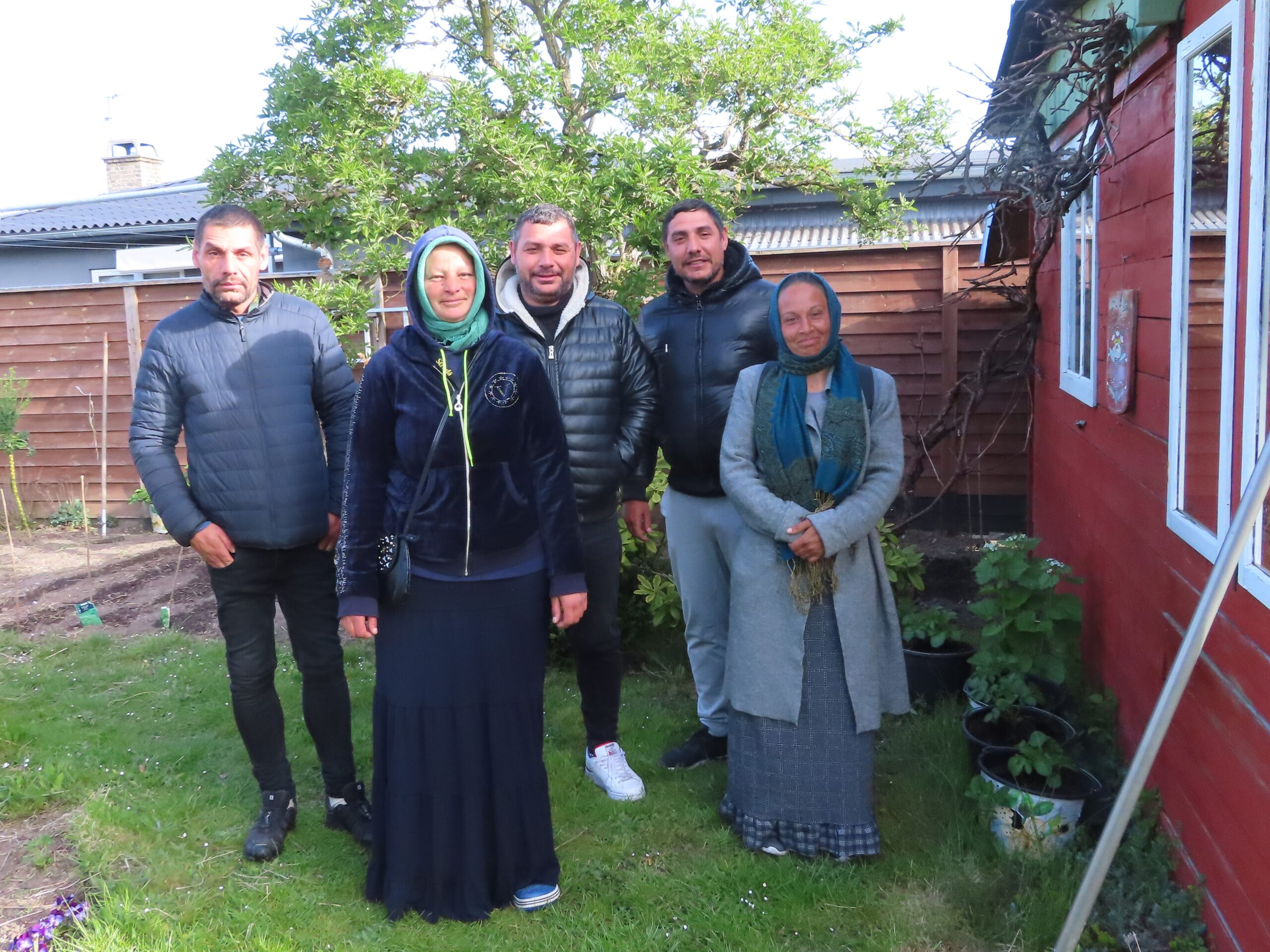 gruppebillede i af fem romaer i en dansk have